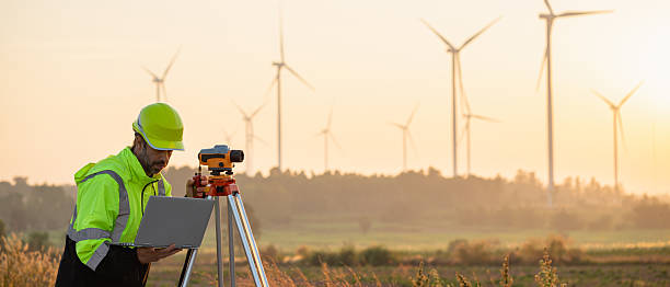istock A field engineer surveys the land at sunset, with wind turbines behind as technology meets clean energy. 2215181292