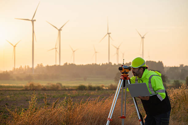 istock A field engineer surveys the land at sunset, with wind turbines behind as technology meets clean energy. 2215181315