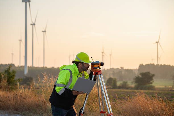 istock A field engineer surveys the land at sunset, with wind turbines behind as technology meets clean energy. 2215181431