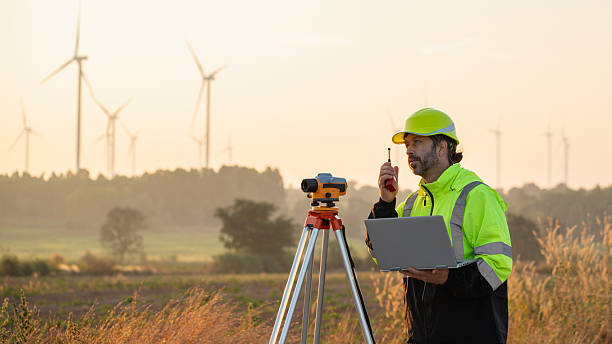 istock A field engineer surveys the land at sunset, with wind turbines behind as technology meets clean energy. 2215181698