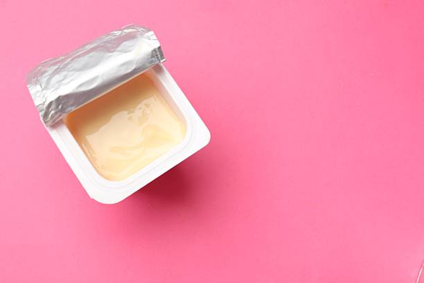 istock Delicious yogurt in plastic cup on pink background, top view. Space for text 2215182169