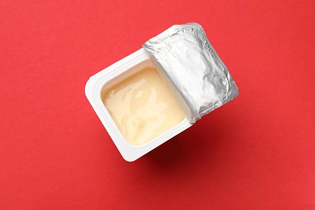 istock Delicious yogurt in plastic cup on red background, top view 2215182206