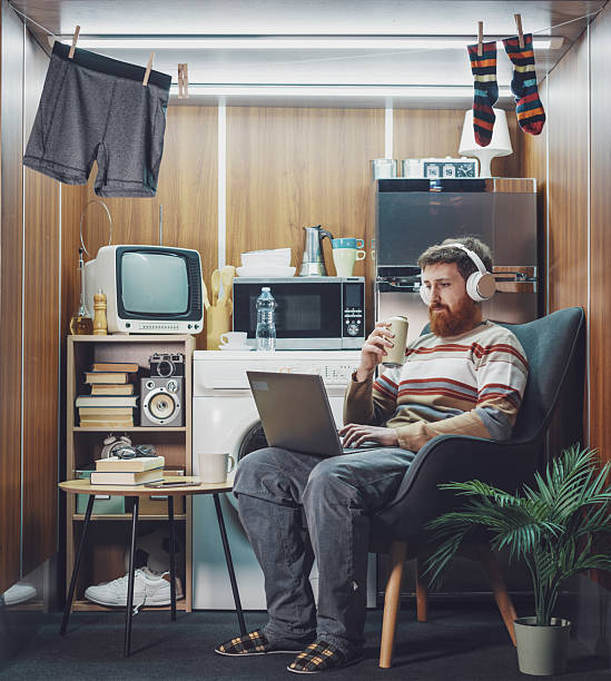 istock Man living in a stuffed one-room micro apartment 2215182935