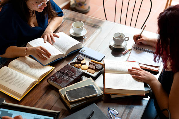istock Book club friends enjoying reading and taking notes at the cafe table 2215183054
