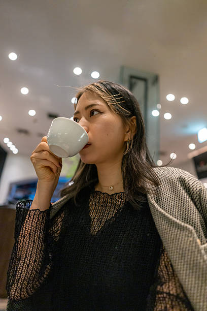 Young female freelance worker drinking a cup of coffee in cafe