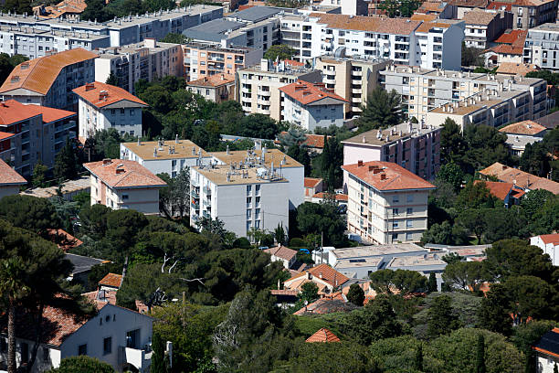 Aerial view from Mont Saint-Clair of traditional red roof houses and apartment buildings in the picturesque town of Sete, France, surrounded by canals, a lagoon and the Mediterranean Sea.