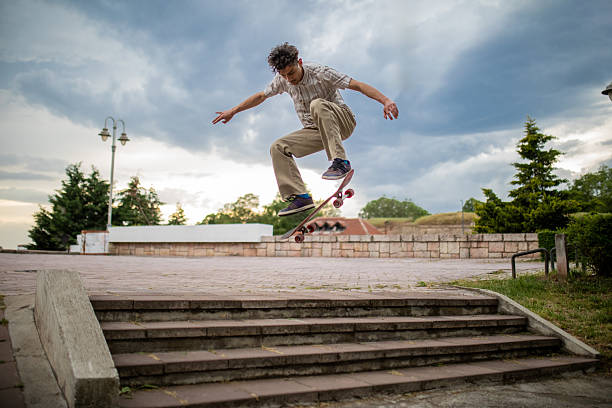 istock Skateboarder Performing Jump in Public Park 2215184336