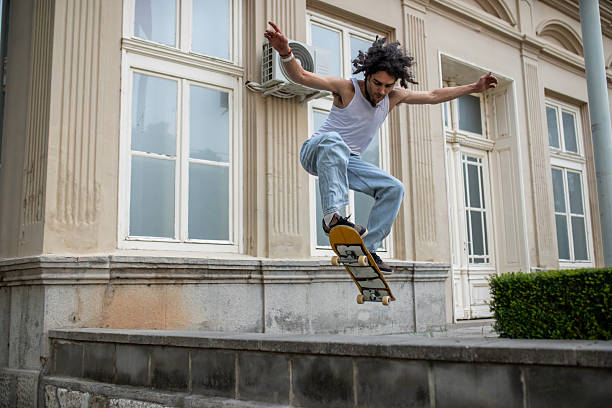A person with yellow pants skates through a bustling urban area. The bright daylight illuminates the surroundings, showcasing movement and energy.