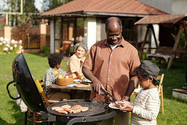 istock Family Gathering Eating Barbecue in Outdoors Area 2215186930