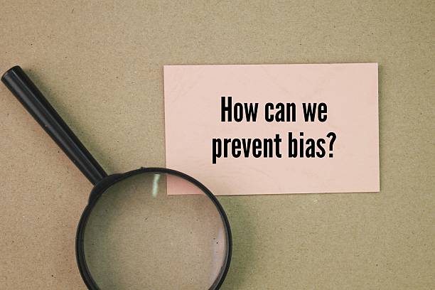 istock Magnifying glass and paper with the question words How can we prevent bias? 2215189452