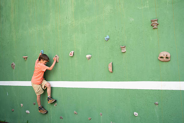 A young female climber climbs the mountain suspended by a rope. Romania, Sohodol. June, 09, 2025.