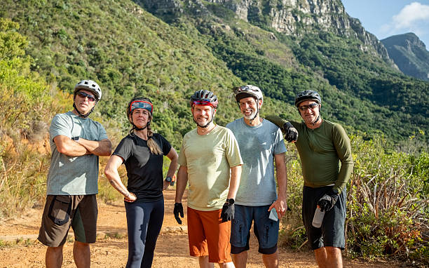 istock Group of cyclists wearing helmets posing in front of mountain range 2215191784