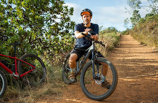 istock Man sitting on mountain bike on dirt path in nature 2215191808