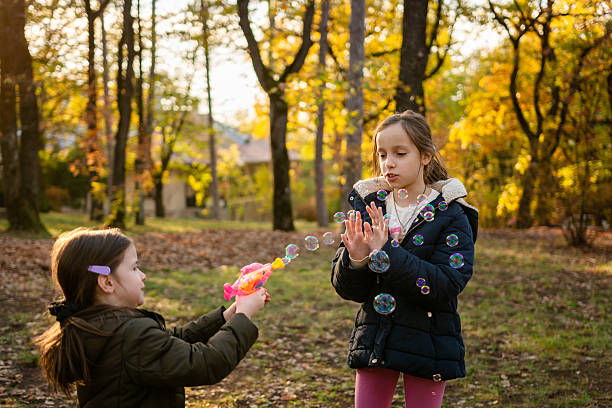istock Girls playing whit bubbles at the park 2215192064