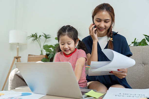 istock Busy mother multitasking with her daughter while working from home, blending responsibilities. 2215194239
