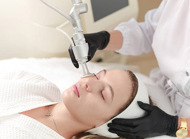 CO2  carbon dioxide laser resurfacing procedure in a Beauty spa salon. Professional dermatologist doctor working on a client. Hardware cosmetology procedure.