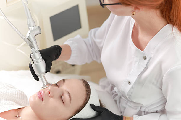 CO2  carbon dioxide laser resurfacing procedure in a Beauty spa salon. Professional dermatologist doctor working on a client. Hardware cosmetology procedure.