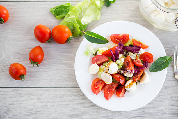 Appetizer with mozzarella, tomatoes and green leaves.