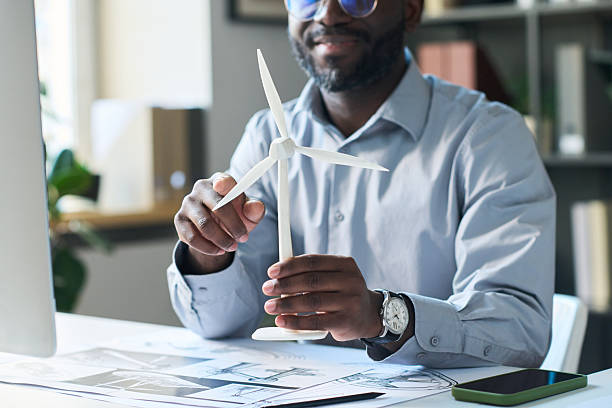 istock Black Male Engineer Holding Wind Turbine Model 2215197731