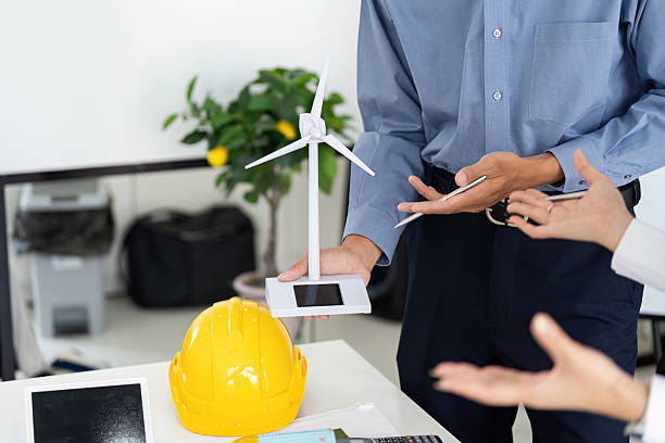 istock Innovation and Renewable Energy. An engineer showcasing a wind turbine model during a project discussion on sustainability. 2215198548