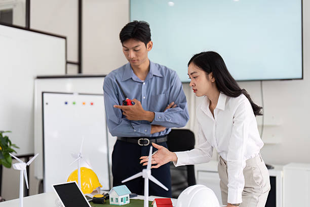 istock Team Collaboration on Sustainable Engineering. Engineers brainstorming solutions for eco-friendly housing designs. 2215198795