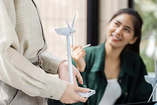 istock Renewable Energy and Teamwork. A professional presenting a model wind turbine during a strategic meeting. 2215200174