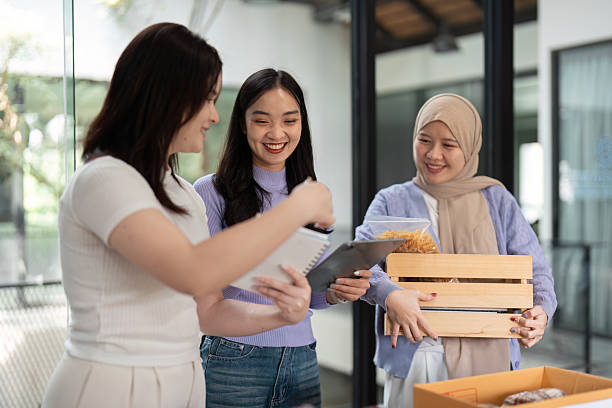 istock Volunteer Work and Donation Efforts. Three women discussing sustainable practices while organizing donations for their community. 2215201945