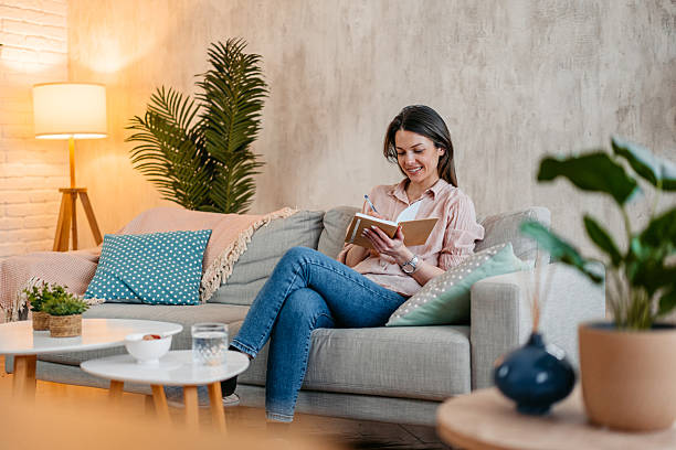 istock Young Woman Writing In A Diary At Home 2215202724