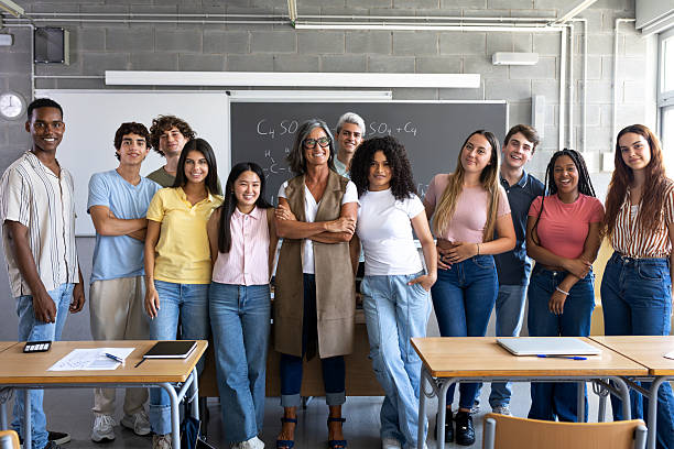 istock Students and teacher smiling in classroom with arms crossed 2215203672