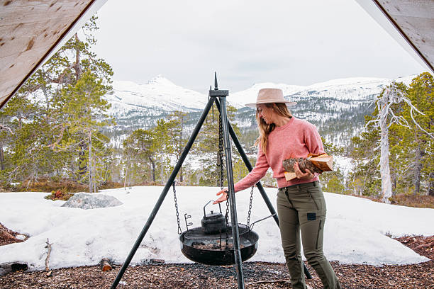 istock Woman Camping in Snowy Mountain Setting Preparing Hot Beverage 2215206336