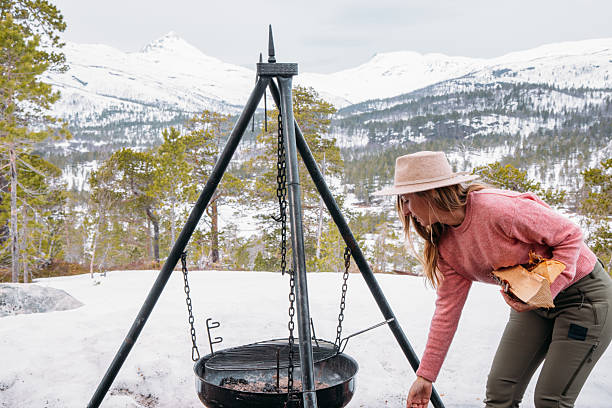 istock Woman Camping in Snowy Mountain Setting Preparing Hot Beverage 2215206340