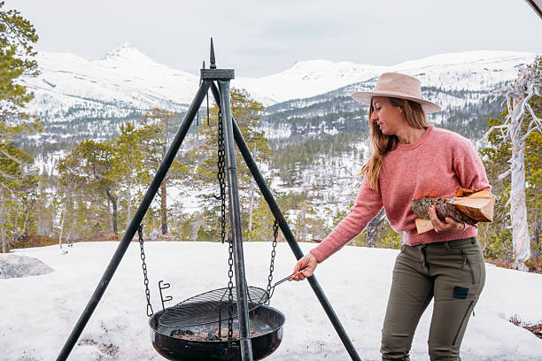 istock Woman Camping in Snowy Mountain Setting Preparing Hot Beverage 2215206349