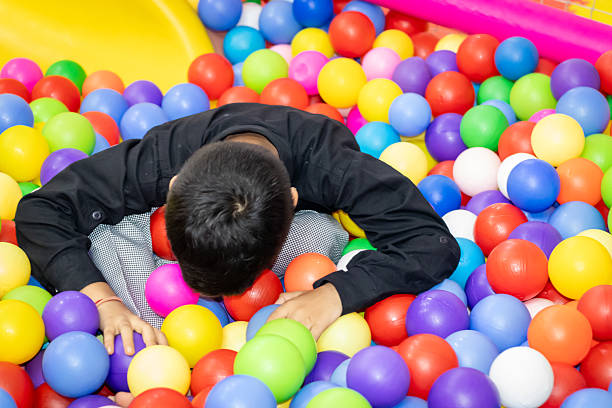 Portrait of children playing on ball pool in the school playroom
