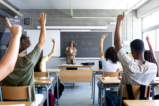 istock High school students raising hands in chemistry class 2215206942