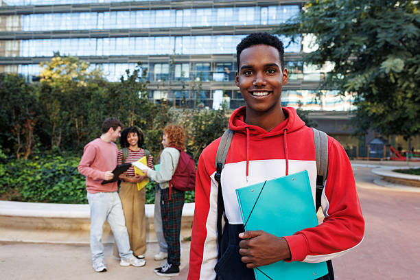 istock Smiling university student holding a binder on campus 2215206950