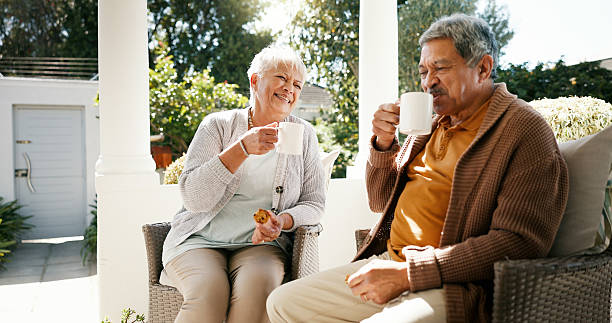 istock Outdoor, old couple and breakfast with tea for love, bonding and biscuits while talking in retirement. Porch, woman and man with happiness for relationship, eating and cookies with coffee in morning 2215207000
