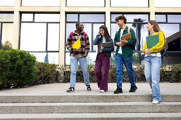 istock Cheerful university students walking and talking on campus 2215207764