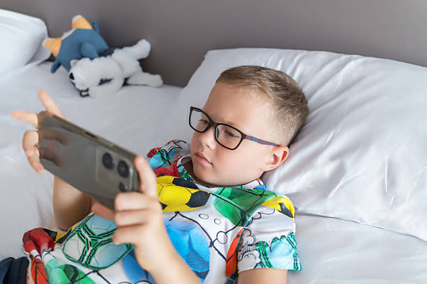istock 6 year old boy plays on smartphone in hotel on holiday 2215211627