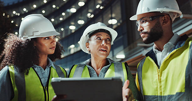 istock Night, engineering and people with tablet, talking and conversation with digital app for checklist. Group, safety or employees with tech, evening or online planning for construction and collaboration 2215212238