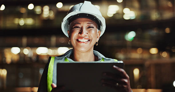 istock Portrait, engineering or happy woman on tablet for urban development, construction site or planning. Night, bokeh or mature engineer in city for building progress, safety inspection or project update 2215212257