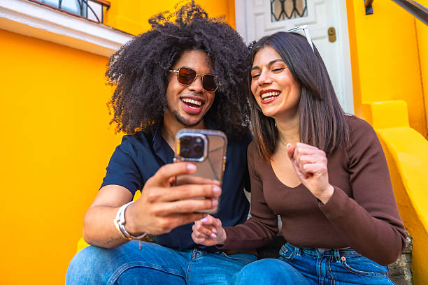 istock Happy couple watching something funny on smartphone 2215213319