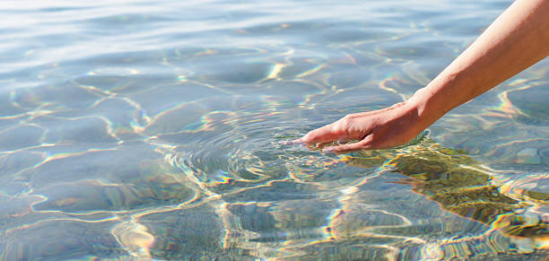 istock A woman's hand touching the sea water. Banner. Copy space. Selective focus. 2215213341