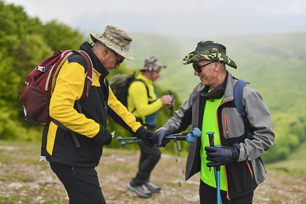 istock Joyful Male Hikers Taking Break on Their Walk Checking Hiking Equipment 2215214552