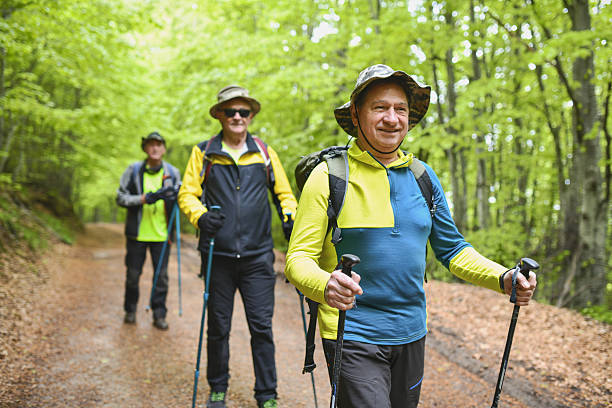 Elderly Male Adventurers Enjoying Nature While Hiking Single File Through Mountain Terrain