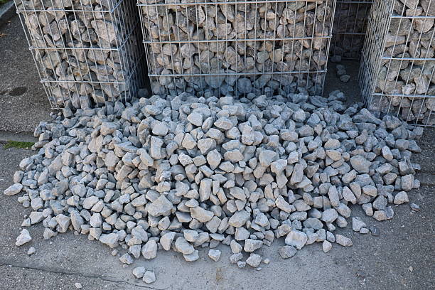 A pile of rocks is sitting on the ground. The rocks are grey and appear to be large. .