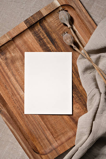 Minimal aesthetic postcard or wedding invitation mockup design template in boho style, empty paper card and dried poppy flowers on brown wooden tray with beige linen tablecloth background.
