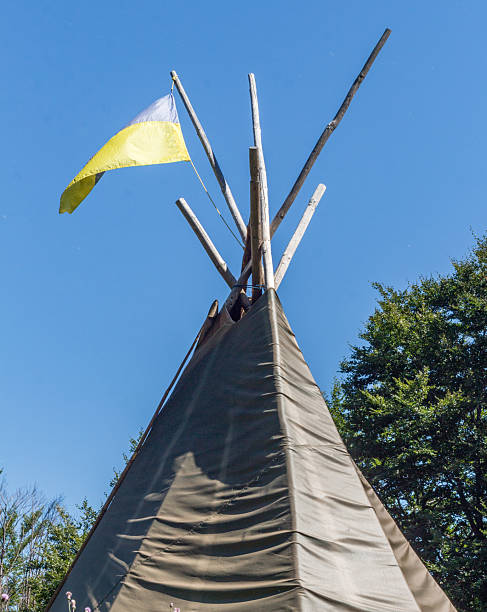 Captured from a low angle, this teepee stands as a symbol of heritage, camping, festivals, or a unique retreat, promising warmth, storytelling, and peaceful moments.