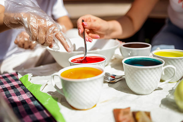 Vibrant Egg Dyeing Activity With Hands and Bowls of Colored Liquid