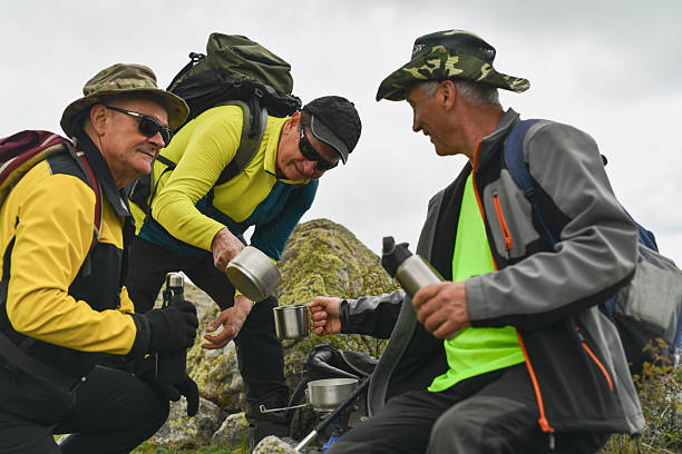 istock Three Male Hikers Refreshing With Coffee and Water at the Mountain Summit 2215225931