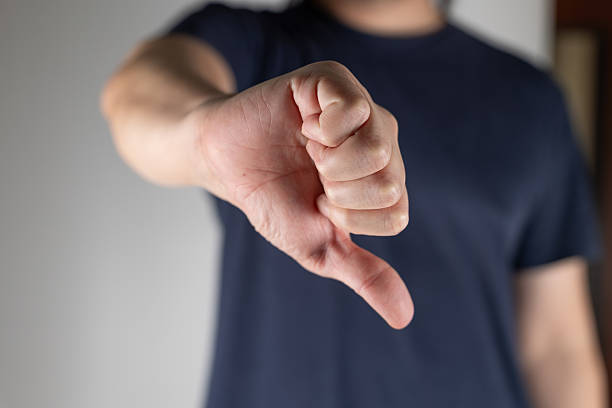 istock A man makes a displeased gesture by pointing his thumb down. 2215228869
